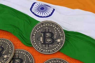 3d rendering of a metallic bitcoin over an indian flag