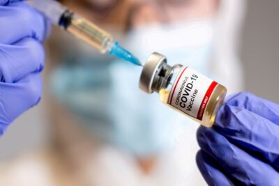 file photo: file photo: a woman holds a medical syringe and a small bottle labelled "coronavirus covid 19 vaccine