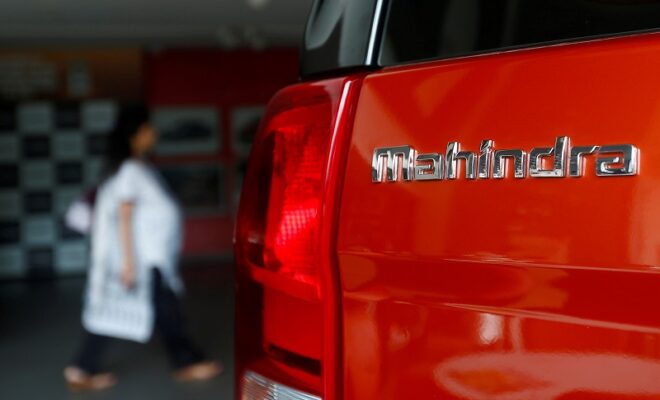 file photo: an employee walks past a mahindra tuv300 car at a showroom in mumbai
