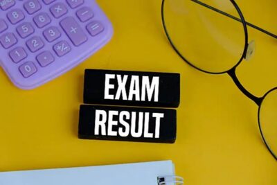 exam result on white pad with exam tools on yellow background