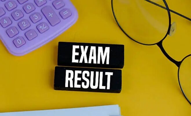 exam result on white pad with exam tools on yellow background