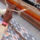 view of indian man weaving cloth on hand loom machine
